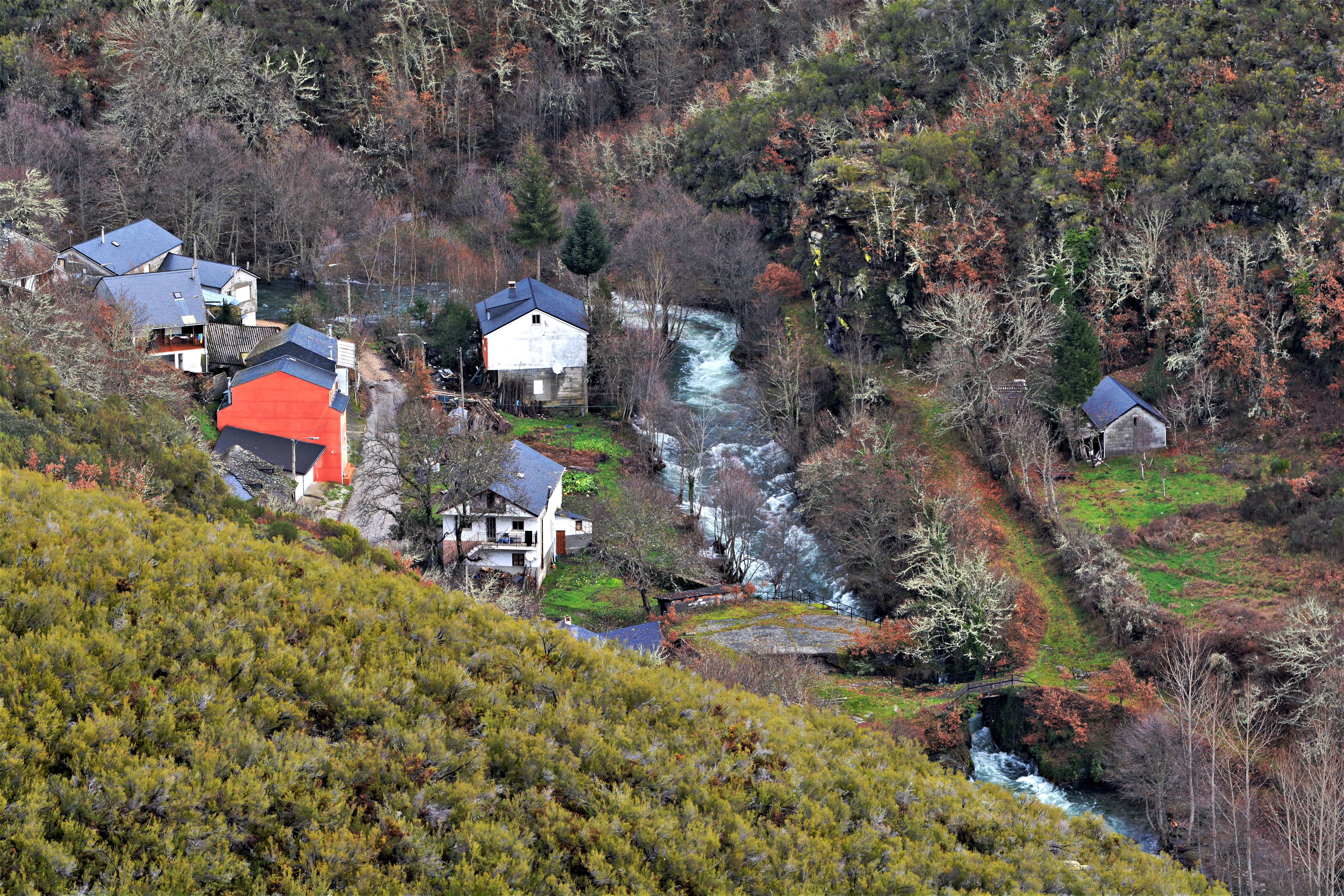 Casas de Aira da Pedra junto al río Burbia, con abundante agua y vegetación. Fotografía: Pepe Couceiro · Lugares con Alma.